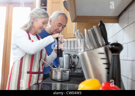 Vieux couple cooking together in kitchen Banque D'Images