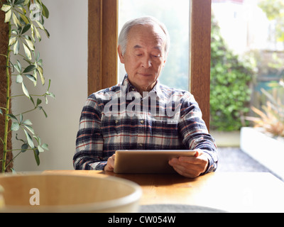 Older Man using tablet computer Banque D'Images