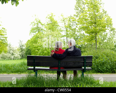Vieux couple sitting on park bench Banque D'Images