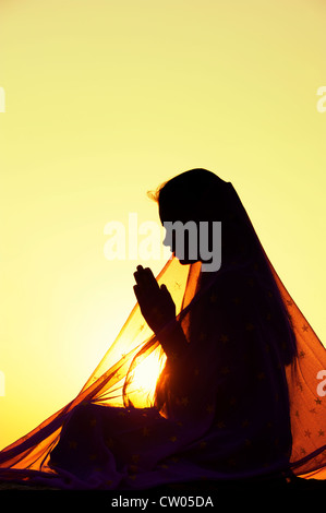 Indian woman praying at sunset couverts par une étoile voile. Silhouette. L'Inde Banque D'Images