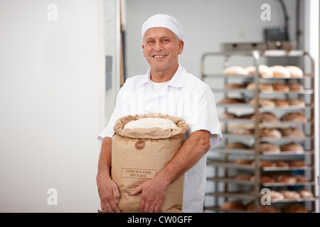 Chef exerçant son sac de farine dans la cuisine Banque D'Images