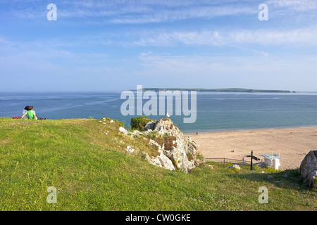 Deux adolescents à l'égard de l'île de Caldey et South Beach, dans le soleil d'été, Tenby, Pembrokeshire, Pays de Galles Parc National Banque D'Images