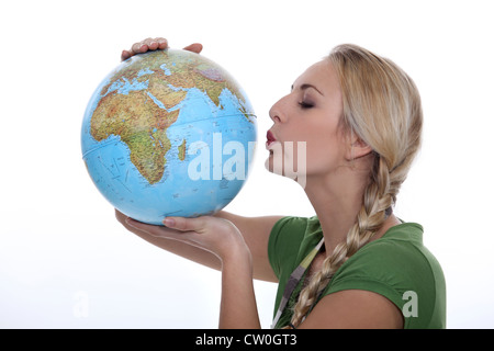 Femme dans un haut vert embrassant un globe Banque D'Images