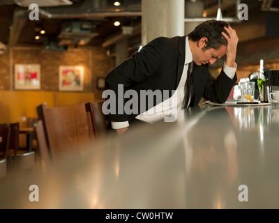 Businessman reading newspaper in cafe Banque D'Images