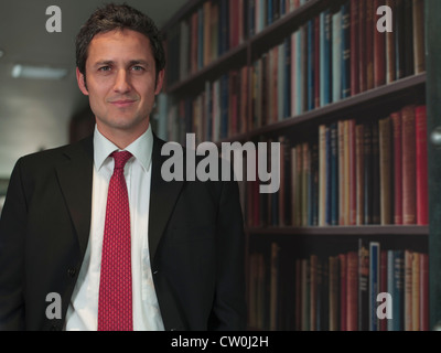 Businessman standing in library Banque D'Images