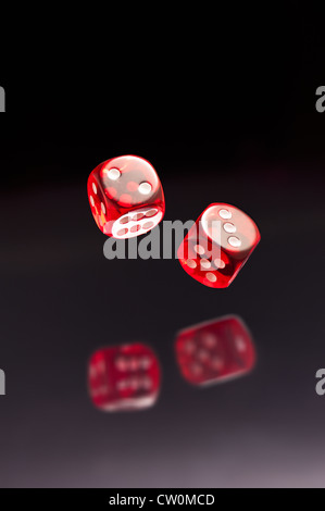 Rolling red dice sur fond gris noir Banque D'Images