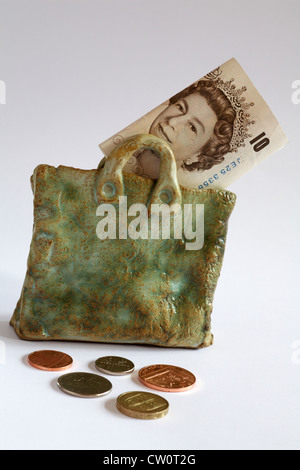 Sac argent - £10 remarque montrant Queen's head en poterie sac avec pièces réparties autour d'isolé sur fond blanc Banque D'Images