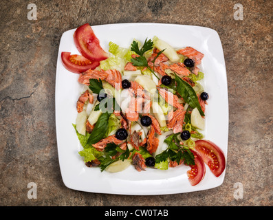 Salade de saumon rouge avec frais jardin tomates, basilic, persil, laitue, oignons, poires on white plate Banque D'Images