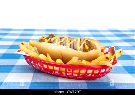 Vue latérale d'un chilidog avec frites sur une nappe à carreaux. Banque D'Images