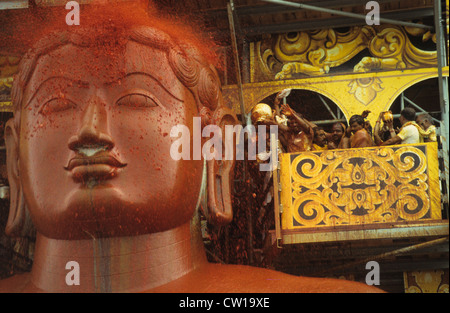 L'INDE, l'état du Karnataka, Hassan district, Shravana Belagola , le Jaïnisme, Jain, Grand festival Mahamastakabisheka consécration, à sculpture monolithique de granit de Saint Seigneur Bahubali, le 57 pieds de statue est taillée dans un seul morceau de rocher en date du 981 après JC et est l'un des plus grands des statues dans le monde, le festival a lieu qu'une fois tous les 12 ans, des milliers de partisans de jain se réunir et verser les liquides d'épices colorées, le lait, le sucre en poudre et fleurs sur la statue d'une construction, religieux face pierre gros gros -image prise au cours de l'année 1994 du festival Banque D'Images