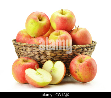 La composition avec des pommes dans le panier en osier isolated on white Banque D'Images