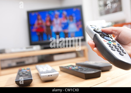 Hot Hand holding remote avec plat en arrière-plan Banque D'Images