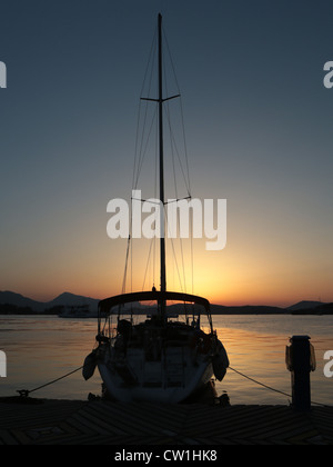 Coucher du soleil sur l'île grecque de Poros avec un yacht amarré dans l'avant-plan Banque D'Images