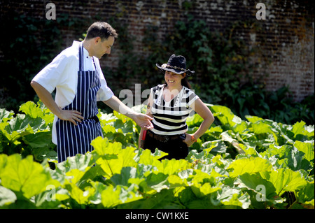 Whitney couvre le chef jardinier avec chef Chris Moore parmi la rhubarbe dans le jardin clos à Newick Park Hotel Banque D'Images