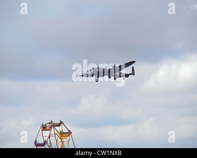 Lancaster dans fly past avec roues vers le bas au-dessus de fille sur la Grande Roue à Essex & de Londres le premier véhicule militaire show. Banque D'Images