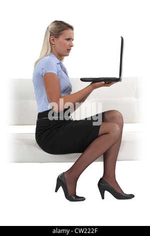 Businesswoman holding son ordinateur portable et à la choqué Banque D'Images