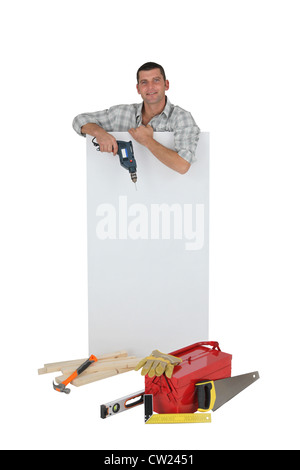 Handyman posing with a blank sign et ses outils Banque D'Images