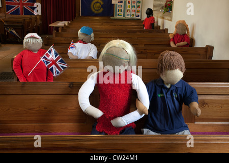 L'église St Mary, Kettlewell. Des poupées de paille en peluche assis en bancs à Kettlewell épouvantail annuel festival, la région de Wharfdale, North Yorkshire, UK Banque D'Images