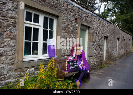 Jenny Joseph. Femme en violet "Prenez un vieux sac shopping' Yorkshire UK ; tableau vivant 2012 Kettlewell épouvantail annuel festival, Yorkshire du Nord. Banque D'Images
