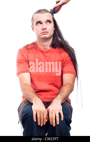 L'homme aux cheveux long malheureux d'être rasé avec cheveux tondeuse, isolé sur fond blanc. Banque D'Images