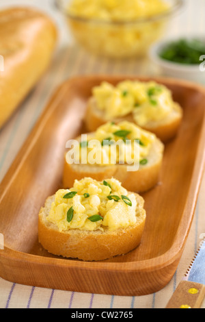 Oeufs brouillés sur tranches de baguette avec l'oignon vert (Selective Focus, se concentrer sur l'avant du premier sandwich) Banque D'Images