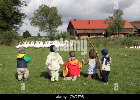 Village resplendissant, regardant un groupe d'enfants sur un pré, Pommerngaense Banque D'Images