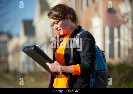 Femme en prenant des notes dans un dossier sur un campus universitaire Banque D'Images