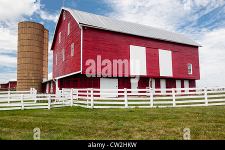 Grange en bois peint rouge avec porte blanche sur ferme dans un style américain traditionnel Banque D'Images