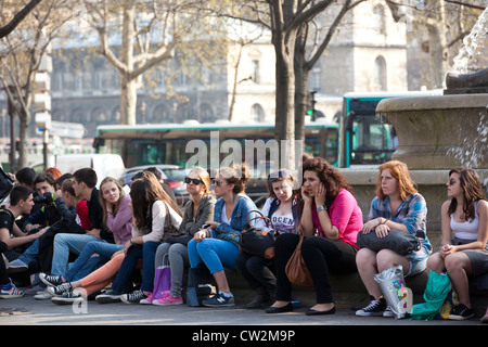 Les étudiants français s'asseoir sous le La Fontaine du palmier à la place du Châtelet, Paris, France. Banque D'Images