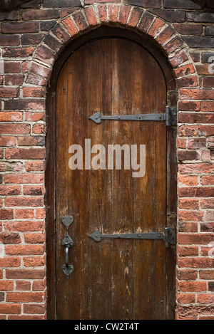 Porte en bois rustique voûté et jardin clos. Banque D'Images