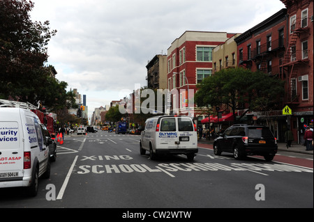 Ciel GRIS les arbres d'automne, rouge tènements, boutiques, white van black car déménagement 1ère avenue à East 9th Street, East Village, New York Banque D'Images