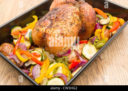 Un prêt à manger des ailes de poulet dans un plat allant au four avec des légumes grillés - studio shot Banque D'Images