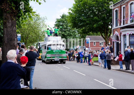 Nouvelle ligne de foules Road, Willenhall, West Midlands pour attendre le passage de la flamme olympique et son porteur précédé de sponsors Banque D'Images