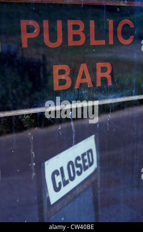 Royaume-uni, Pays de Galles, Dyfed, Détail de fenêtre sale avec la réflexion de route et affiches à l'intérieur indiquant Bar Public et fermé Banque D'Images