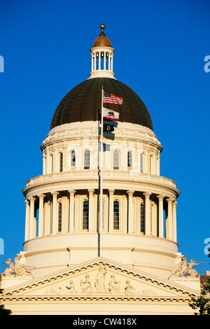 Ce State Capitol dome coucher du soleil. Il a plusieurs drapeaux flottant au vent sur un mât à l'avant-haut un drapeau américain. Banque D'Images