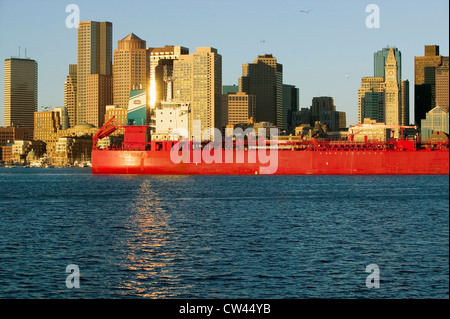 Voyages cargo rouge vif devant le port de Boston et le Boston skyline lever du soleil vu de South Boston Massachusetts New Banque D'Images