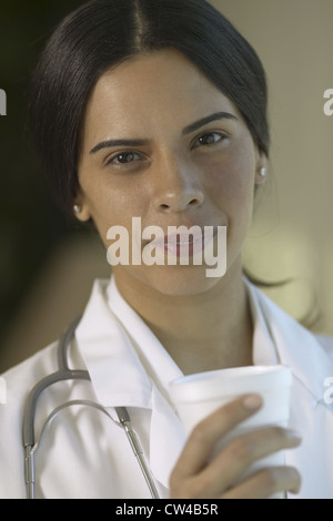 Portrait of a female doctor holding a disposable cup Banque D'Images