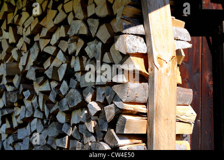 Neat pile de bois haché séchant au soleil pour être utilisé comme carburant d'hiver Banque D'Images