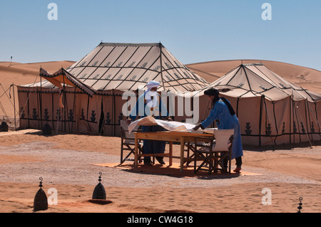 Berbères mis la table dans un luxueux camp dans le désert du Sahara de l'Erg Chigaga, Maroc Banque D'Images