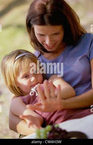 Close-up d'une fille assise sur les genoux de sa mère Banque D'Images