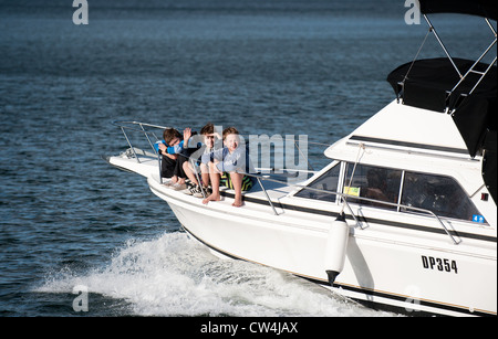 Swan River en Australie occidentale - Trois jeunes garçons assis sur la proue d'un bateau de vitesse sur la rivière Swan en Australie-Occidentale. Banque D'Images