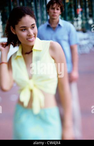 Close-up of a Teenage girl smiling avec un adolescent debout derrière elle Banque D'Images