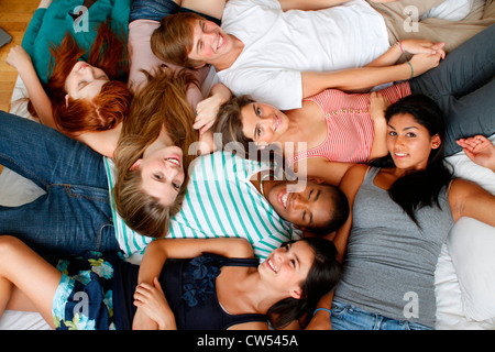 USA, New York, Manhattan, Group of Teenage friends lying on bed Banque D'Images