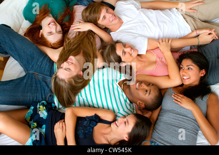 USA, New York, Manhattan, Group of Teenage friends lying on bed Banque D'Images