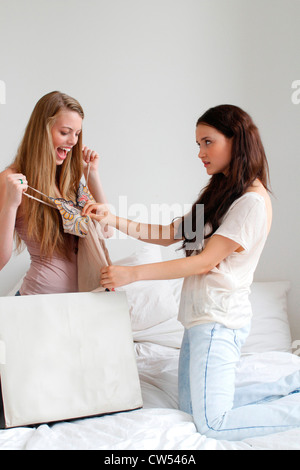 USA, New York City, Manhattan, deux filles avec Shopping bag on bed Banque D'Images