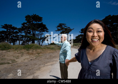 Mature Woman holding a young man's hand and smiling Banque D'Images