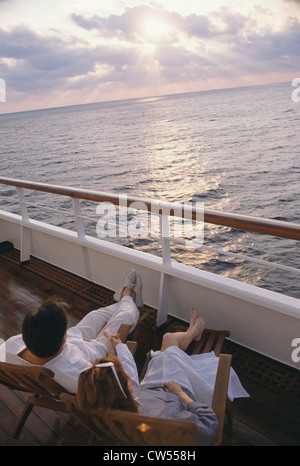 High angle view of a young couple sitting in transats sur un bateau de croisière Banque D'Images