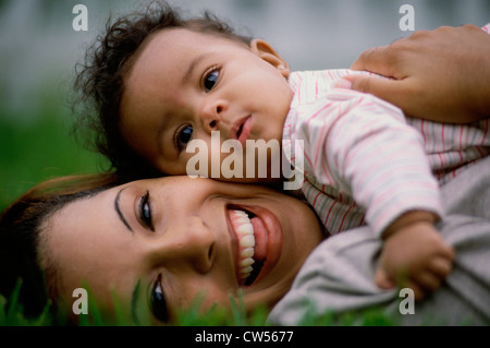 Portrait of a Mid adult woman lying on grass avec son fils Banque D'Images