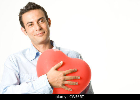 Close-up d'un jeune homme tenant un ballon en forme de coeur Banque D'Images