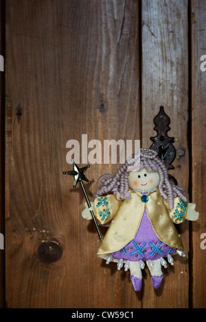 Childs Angel doll accroché sur une porte en bois Banque D'Images